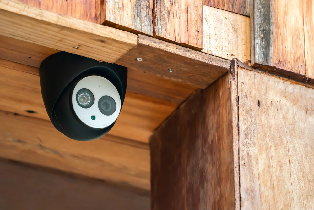 Nahaufnahme einer Mini-Überwachungskamera unter Holzdach