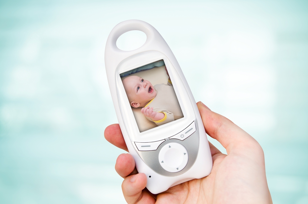 Babyphone mit Videomonitor, das in einer Hand gehalten wird