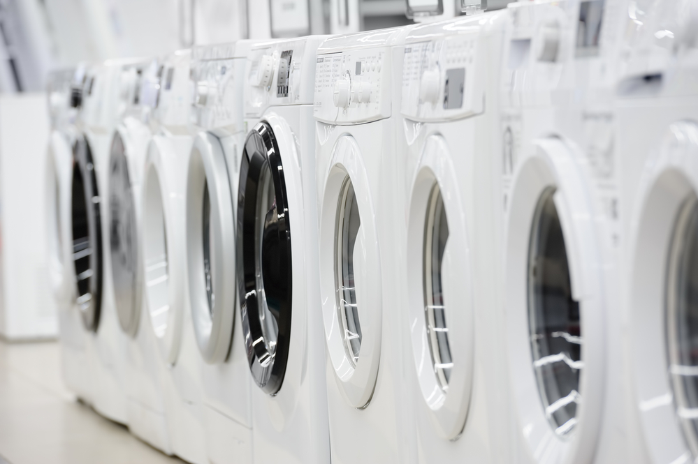 Reihe neuer weißer Waschmaschinen in Verkaufsraum