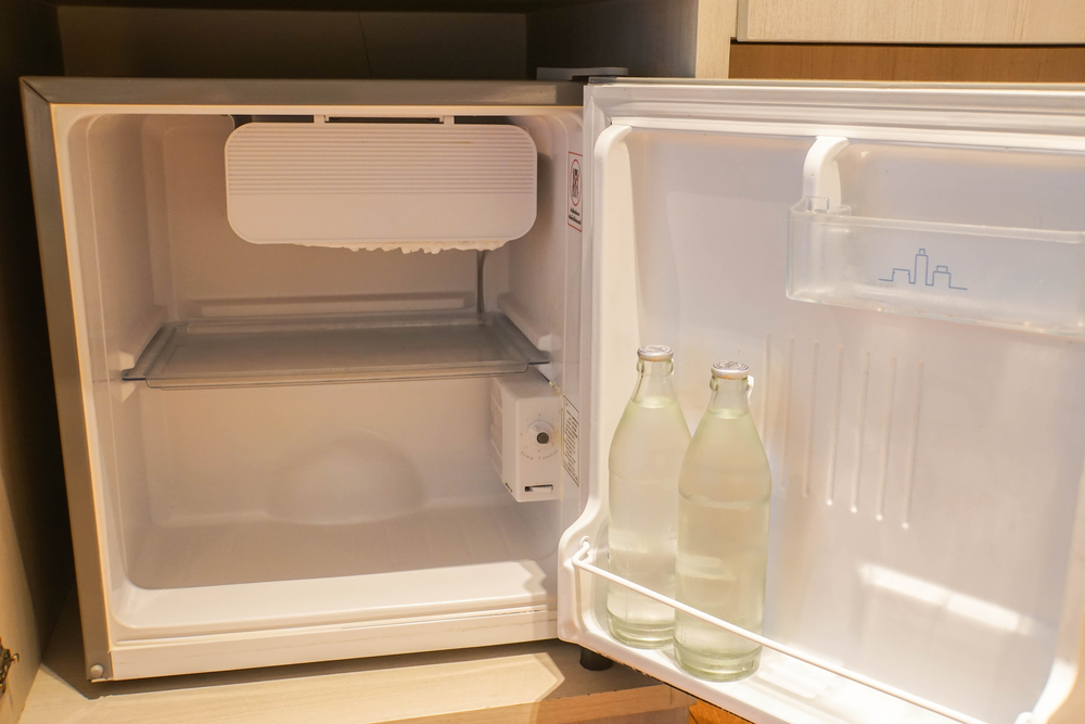 Innenansicht eines Mini-Kühlschranks, in dem zwei Wasserflaschen stehen