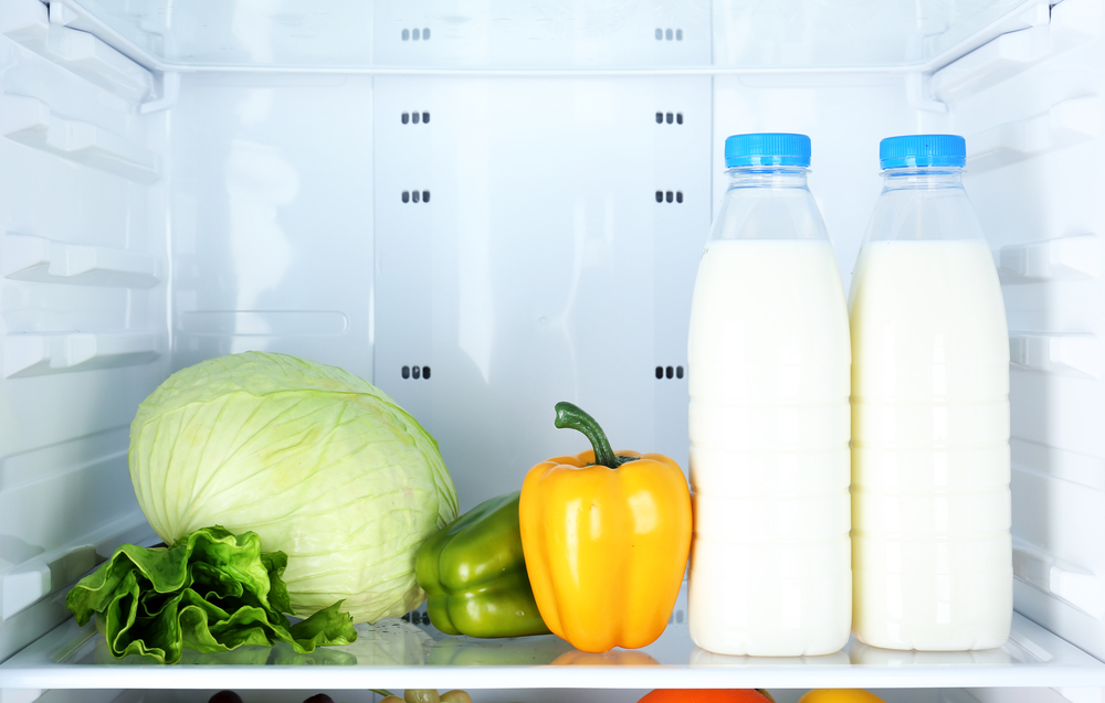 Mit zwei Milchflaschen und Gemüse gefüllter Kühlschrank