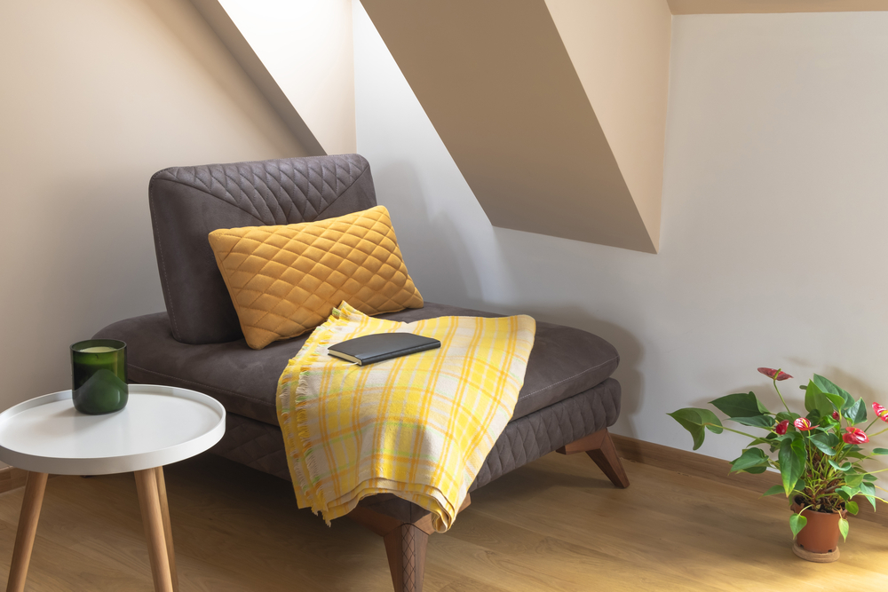 Sessel mit Decke und Beistelltisch unter Dachschräge