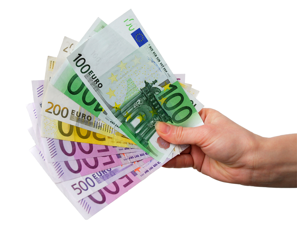 Hand mit verschiedenen Euro-Scheinen vor weißem Hintergrund