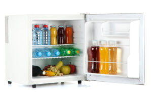 Weißer Mini-Kühlschrank gefüllt mit verschiedenen Getränkeflaschen