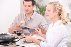 Ein junger Mann und eine junge Frau essen Raclette